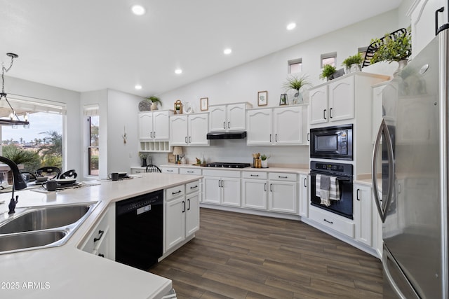 kitchen with dark wood-type flooring, sink, decorative light fixtures, black appliances, and white cabinets