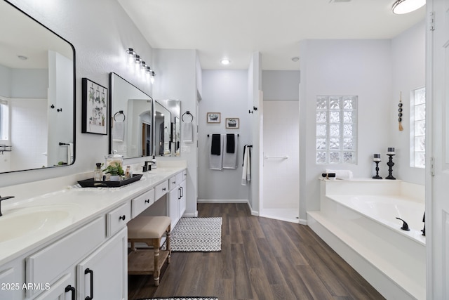 bathroom with wood-type flooring, separate shower and tub, and vanity