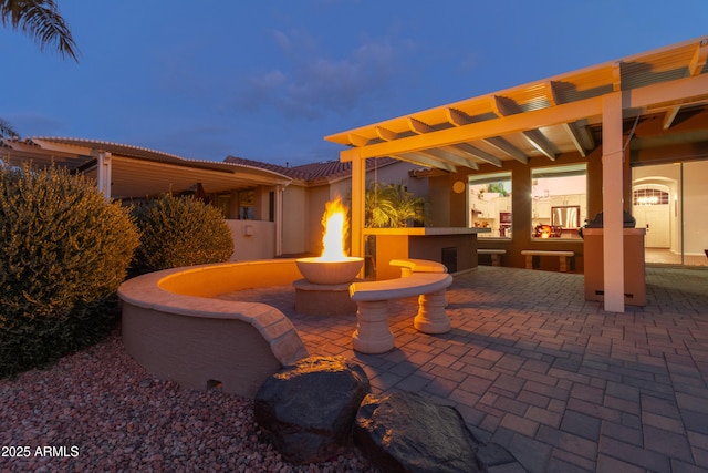 patio terrace at dusk featuring a fire pit