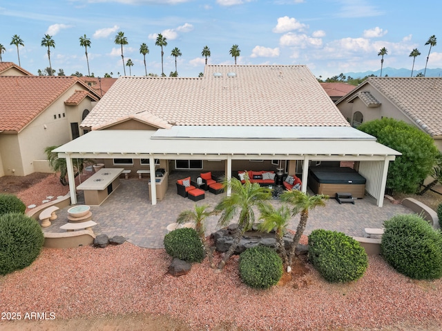 back of house with a hot tub and an outdoor living space