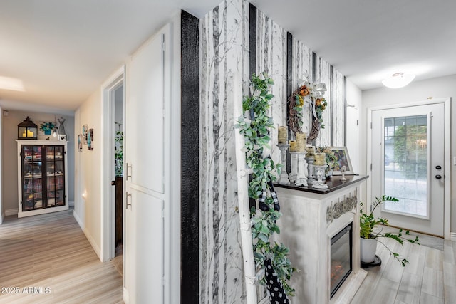 corridor featuring baseboards and light wood-style floors