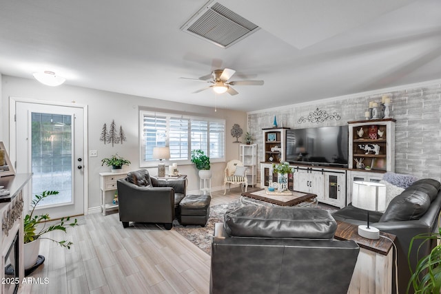 living area with visible vents, baseboards, a ceiling fan, and wood finished floors