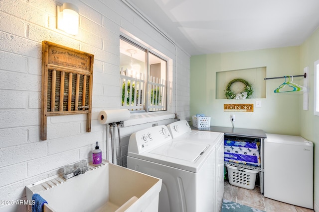 laundry area featuring a sink, separate washer and dryer, a healthy amount of sunlight, and laundry area