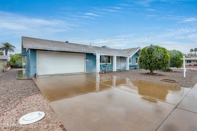 single story home with a garage, roof with shingles, and driveway