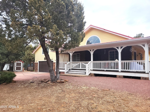 view of front of property with covered porch, a garage, and a storage unit