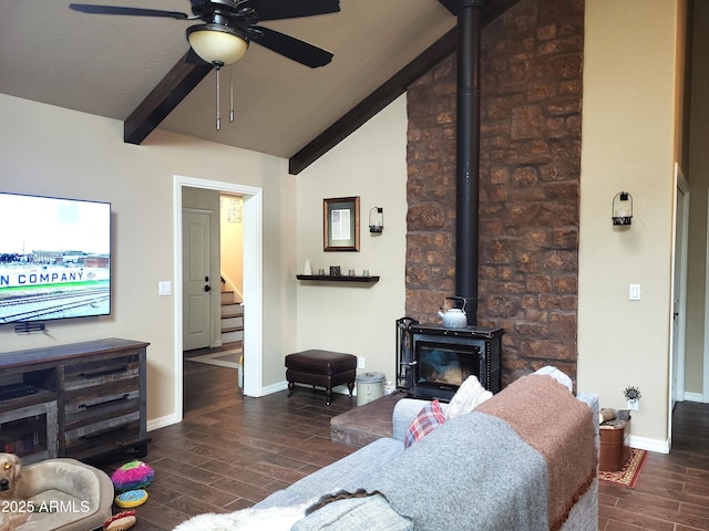 living room with ceiling fan, dark hardwood / wood-style floors, lofted ceiling with beams, and a wood stove