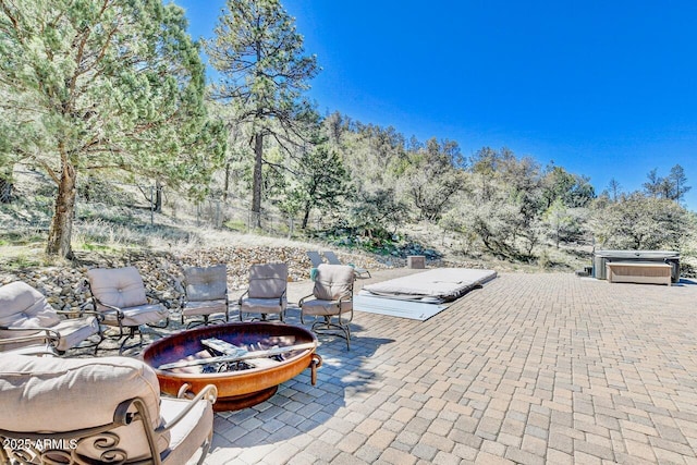 view of patio with an outdoor fire pit and a hot tub