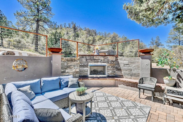 view of patio featuring an outdoor living space with a fireplace