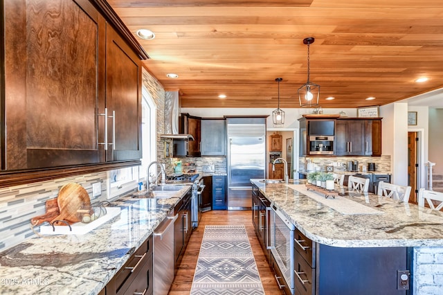 kitchen featuring high quality appliances, backsplash, and a spacious island