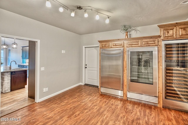 kitchen featuring hardwood / wood-style floors, built in fridge, sink, and wine cooler