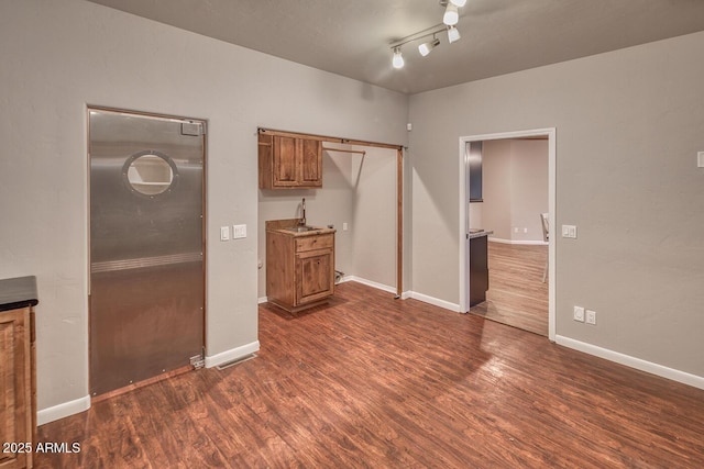 interior space featuring sink, dark hardwood / wood-style flooring, and track lighting