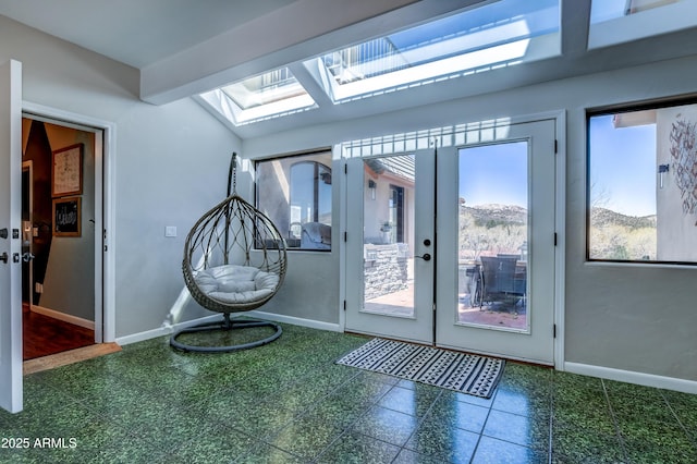 doorway to outside with french doors and lofted ceiling with skylight