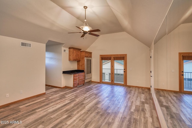 unfurnished living room featuring vaulted ceiling, ceiling fan, and hardwood / wood-style floors