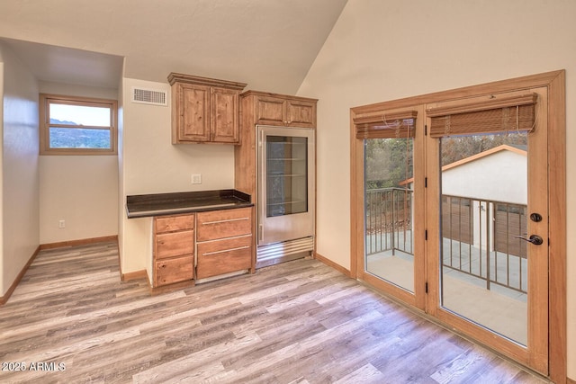 kitchen featuring lofted ceiling and light hardwood / wood-style floors