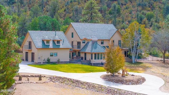 view of front of property featuring a front yard and a balcony