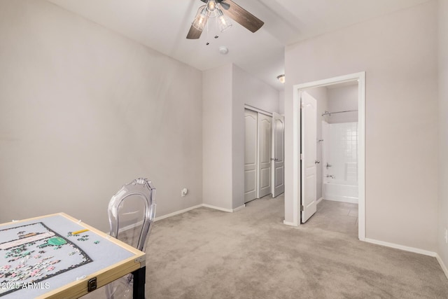 carpeted office space with ceiling fan