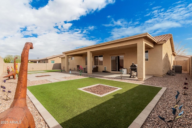 rear view of property with central AC, a patio area, and a lawn