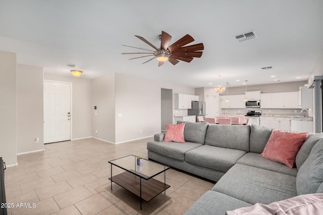 living room with light tile patterned floors, sink, and ceiling fan