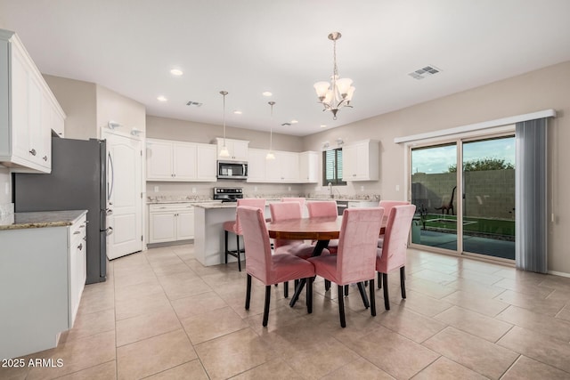 dining room with light tile patterned flooring and a chandelier