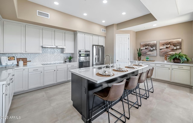 16255 E Ridgeline Dr, Fountain Hills, AZ 85268 - kitchen featuring a sink, a breakfast bar, under cabinet range hood, stainless steel appliances, and visible vents