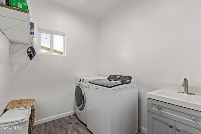 laundry room with cabinets, washing machine and dryer, and sink