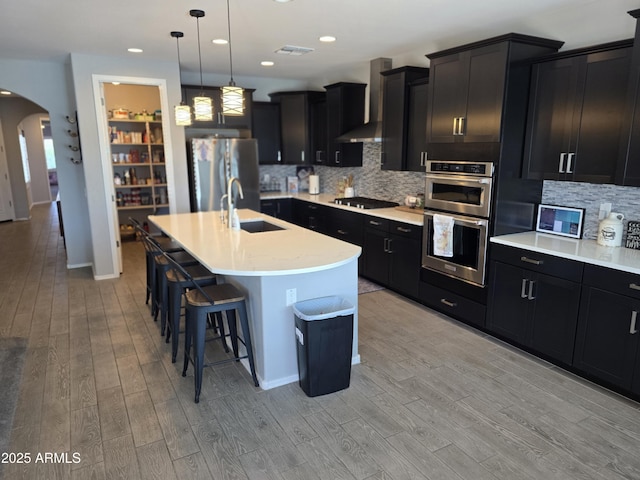 2316 N Crestwood Dr, Florence, AZ 85132 - kitchen with dark cabinets, a sink, appliances with stainless steel finishes, and arched walkways