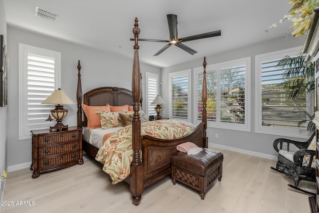 bedroom featuring multiple windows, ceiling fan, and light wood-type flooring