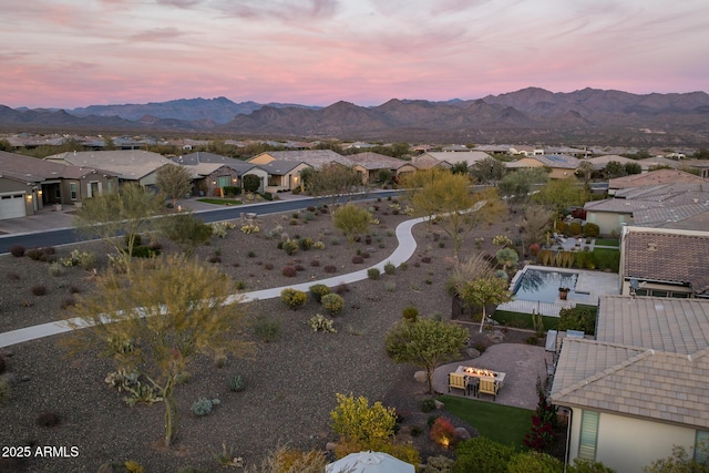 aerial view at dusk featuring a mountain view