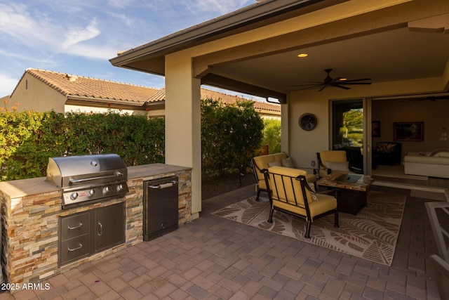 view of patio featuring ceiling fan, area for grilling, and a grill