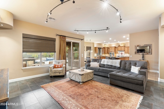 living room featuring rail lighting and an inviting chandelier