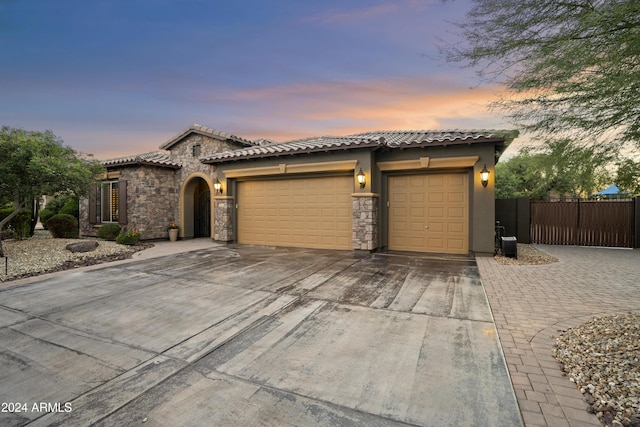 2378 N 158th Dr, Goodyear, AZ 85395 - mediterranean / spanish-style house with driveway, an attached garage, stucco siding, a tiled roof, and stone siding