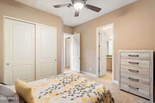 carpeted bedroom featuring ensuite bathroom, ceiling fan, and a closet