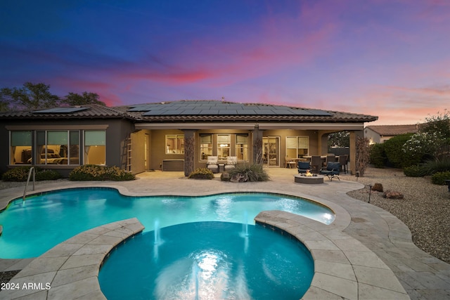 2378 N 158th Dr, Goodyear, AZ 85395 - back of house featuring a patio, stucco siding, a tiled roof, a hot tub, and roof mounted solar panels