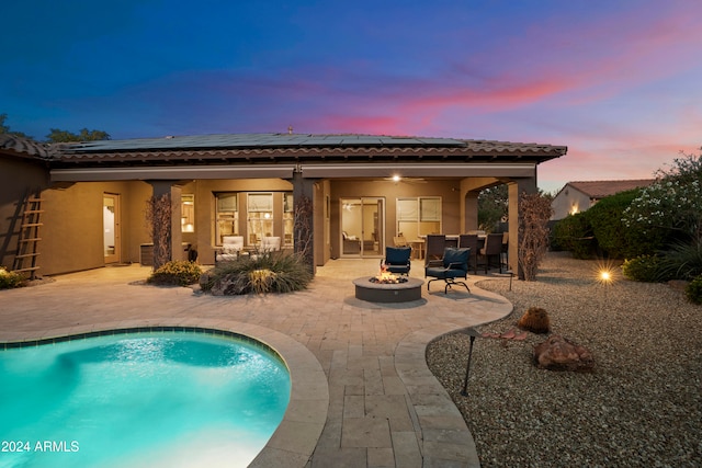 back house at dusk with a patio area and a fire pit