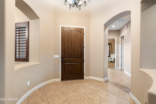 entrance foyer featuring light tile patterned floors and a notable chandelier