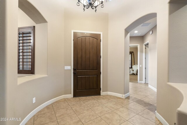 2378 N 158th Dr, Goodyear, AZ 85395 - entrance foyer featuring light tile patterned floors, arched walkways, baseboards, and a chandelier