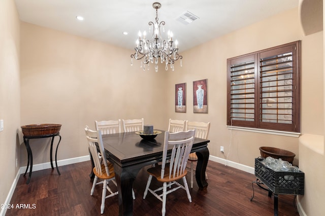 dining area with dark hardwood / wood-style floors and an inviting chandelier