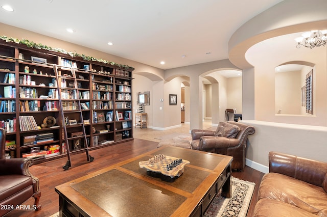 living room featuring wood-type flooring and an inviting chandelier