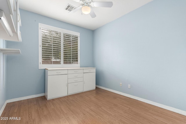 spare room featuring visible vents, baseboards, light wood-style floors, and a ceiling fan