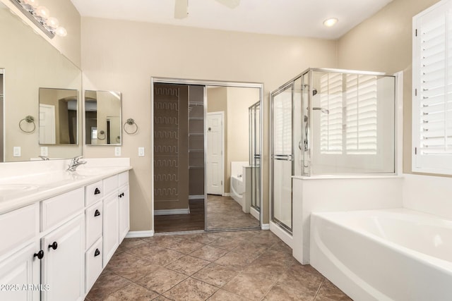 bathroom with a shower stall, double vanity, a bath, a ceiling fan, and a sink