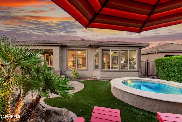 28878 N 127th Ln, Peoria, AZ 85383 - back of property at dusk featuring stucco siding and an outdoor hot tub