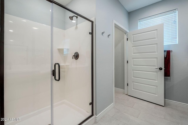 bathroom featuring tile patterned floors and a shower with shower door