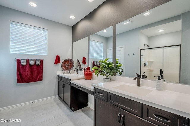 bathroom featuring tile patterned floors, vanity, and a shower with door