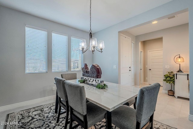 tiled dining room with a chandelier