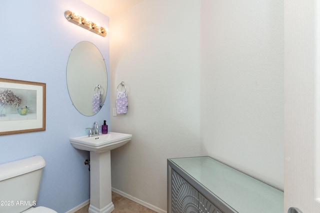 bathroom with baseboards and toilet