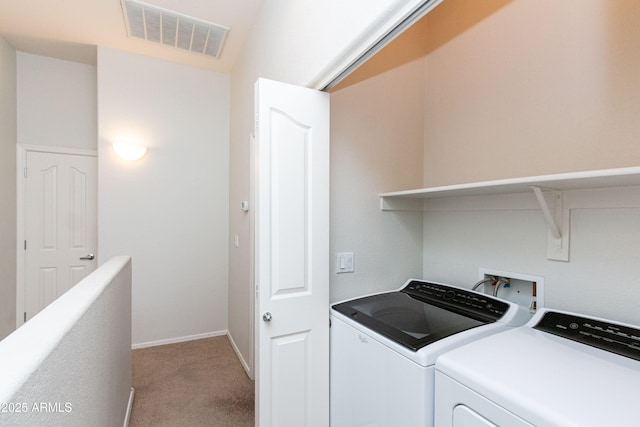 clothes washing area with washer and clothes dryer, visible vents, light carpet, laundry area, and baseboards