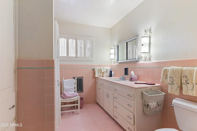 bathroom featuring vanity, toilet, and tile walls