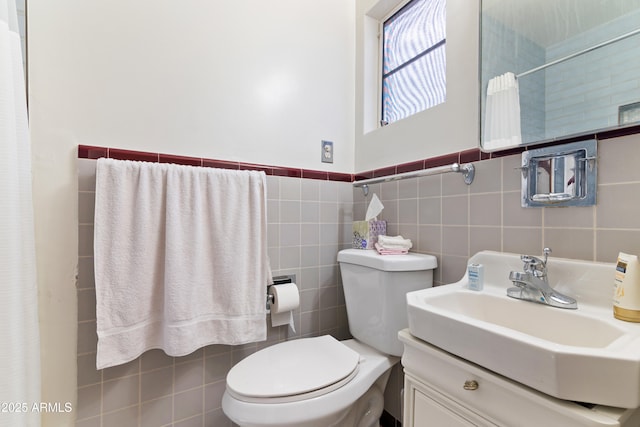 bathroom with vanity, tile walls, and toilet