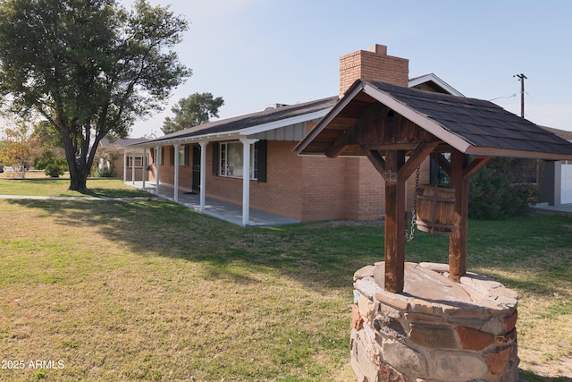 view of property exterior with a patio and a lawn