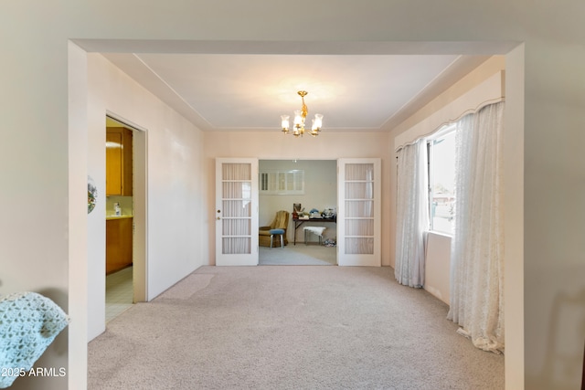 hall featuring french doors, light colored carpet, and a notable chandelier